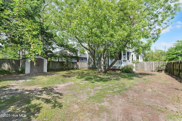 view of yard with a storage shed, an outdoor structure, and a fenced backyard