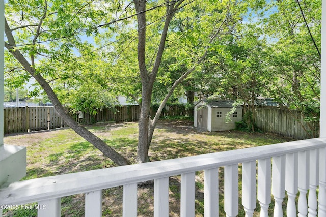 view of yard featuring a fenced backyard, a storage unit, and an outbuilding