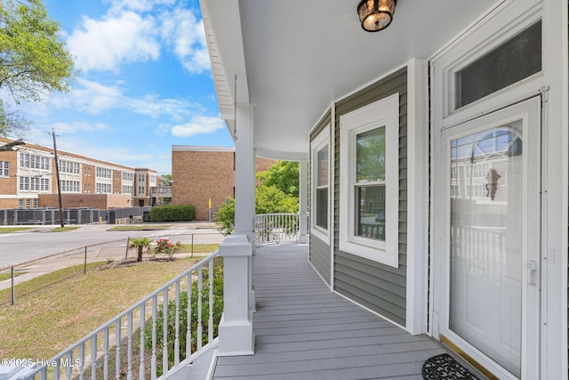 wooden terrace with a porch and a lawn