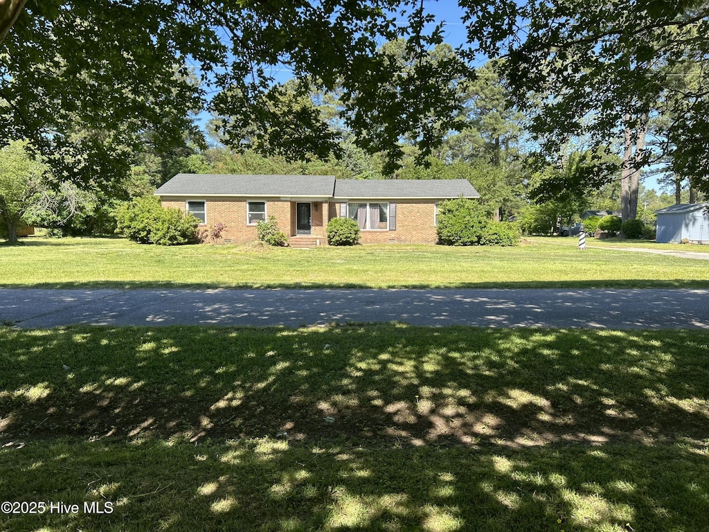 ranch-style house featuring a front lawn and brick siding