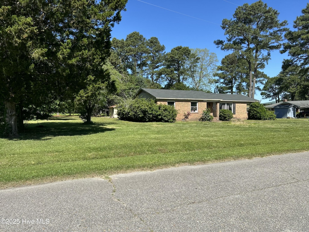ranch-style home featuring brick siding and a front yard