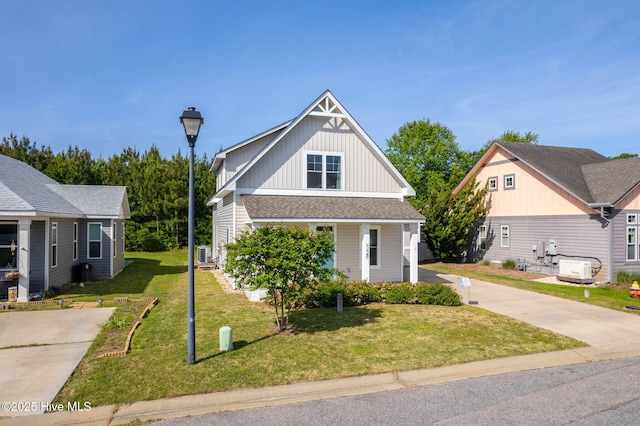 bungalow-style home featuring a front lawn, central AC, covered porch, board and batten siding, and concrete driveway