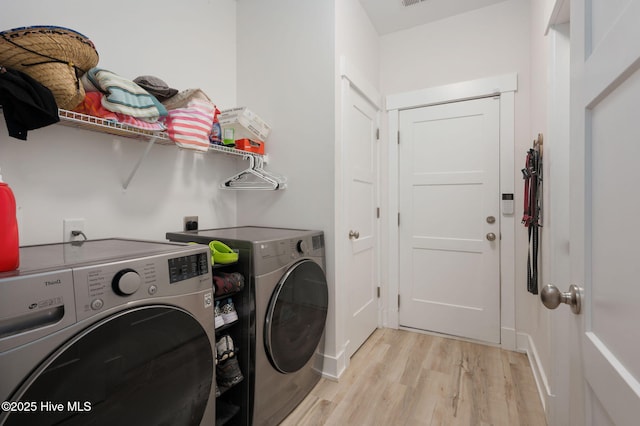 laundry area with separate washer and dryer, laundry area, and light wood finished floors