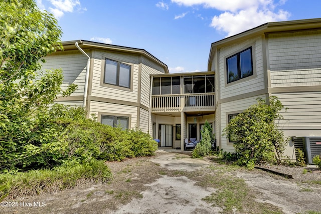 back of house featuring a sunroom and central air condition unit
