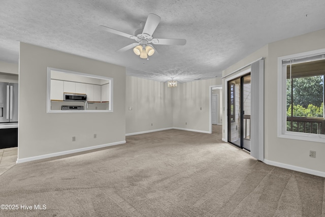 unfurnished living room with carpet flooring, a ceiling fan, and a textured ceiling