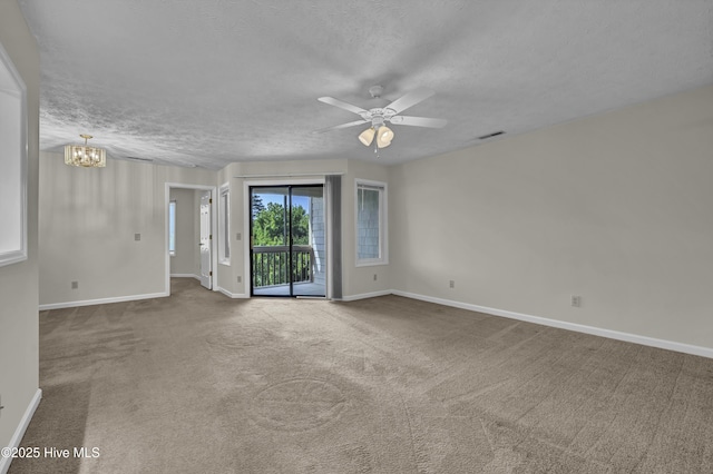 carpeted empty room featuring baseboards, ceiling fan with notable chandelier, a textured ceiling, and visible vents