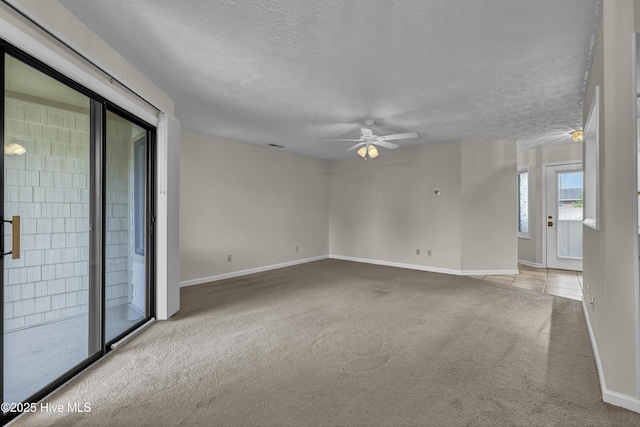 spare room featuring baseboards, a textured ceiling, carpet, and a ceiling fan