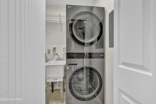 laundry room with laundry area, stacked washer and clothes dryer, and a sink