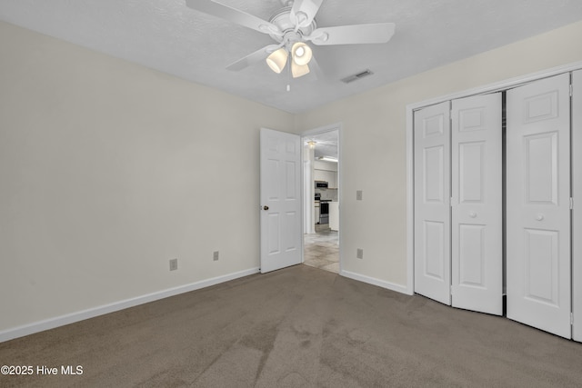 unfurnished bedroom featuring visible vents, a ceiling fan, a closet, baseboards, and carpet flooring