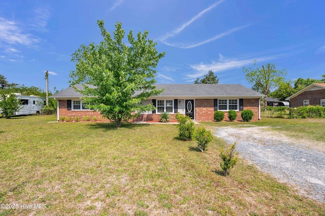 ranch-style house with gravel driveway, a front lawn, and brick siding