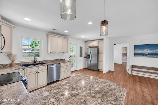 kitchen with visible vents, pendant lighting, appliances with stainless steel finishes, a sink, and cream cabinetry
