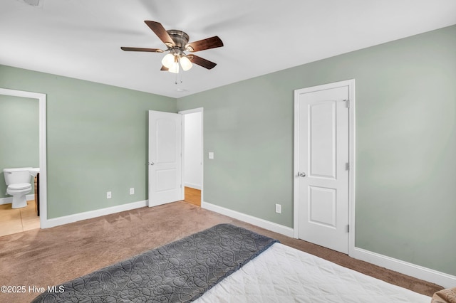 unfurnished bedroom with carpet flooring, a ceiling fan, baseboards, and ensuite bathroom
