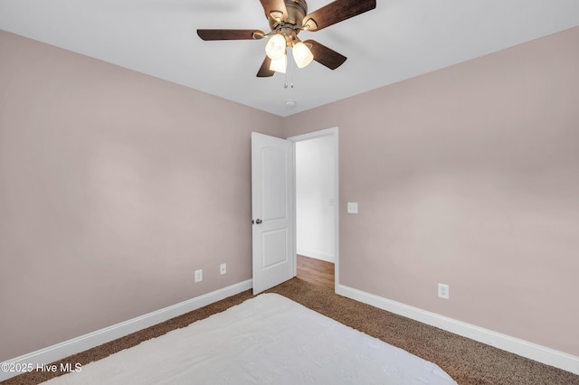carpeted bedroom featuring baseboards and a ceiling fan