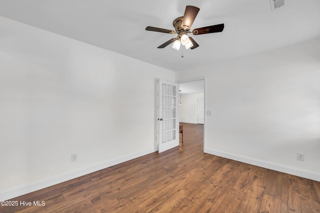spare room featuring baseboards, a ceiling fan, wood finished floors, and visible vents