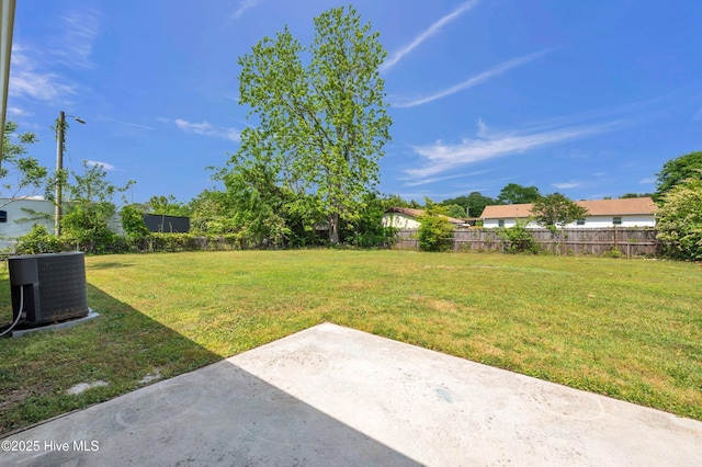 view of yard with a patio, fence, and central AC unit