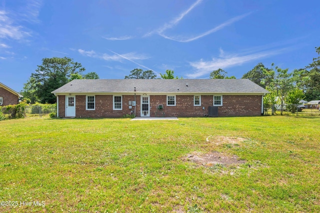 rear view of property with a patio, a fenced backyard, a lawn, and central air condition unit