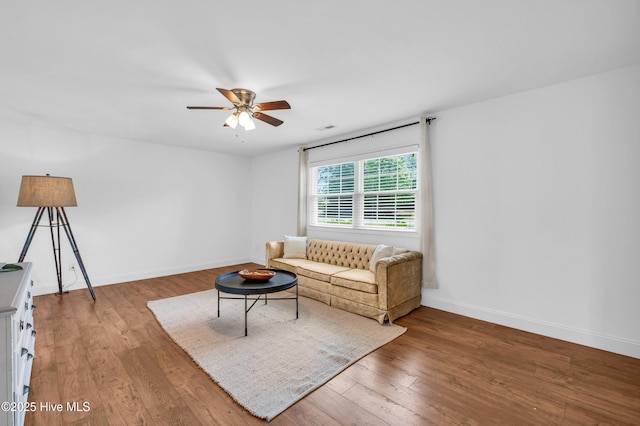 living area featuring baseboards, ceiling fan, wood finished floors, and visible vents