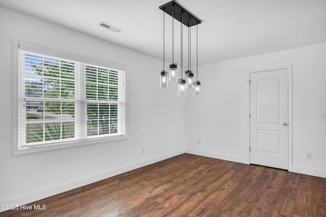 unfurnished dining area with visible vents, dark wood-style flooring, and baseboards