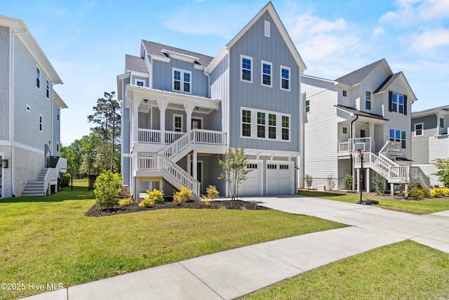 coastal home with a front lawn, a garage, board and batten siding, stairway, and driveway