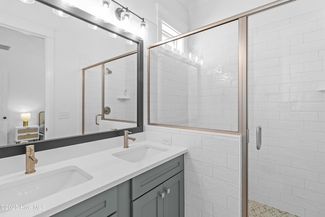 ensuite bathroom featuring double vanity, a sink, ensuite bath, and a stall shower