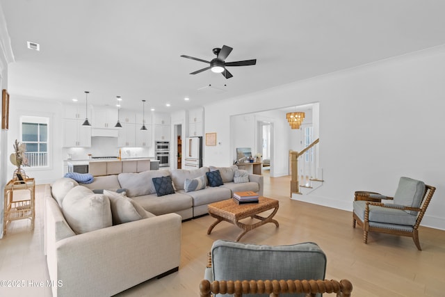 living area with light wood-style flooring, recessed lighting, a ceiling fan, visible vents, and stairway
