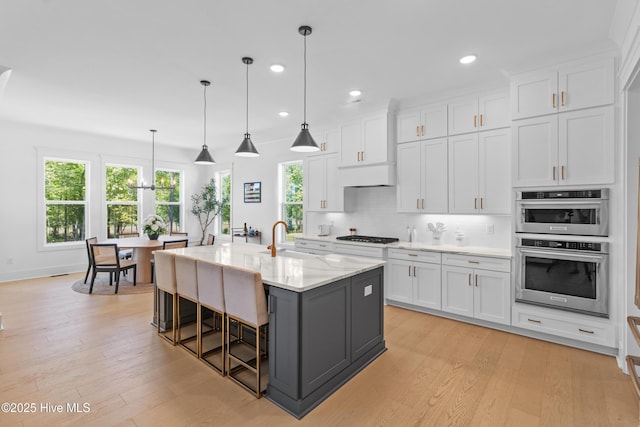 kitchen with white cabinetry, a sink, and light wood-type flooring