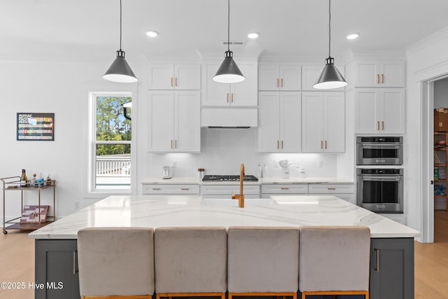 kitchen with visible vents, light wood-type flooring, white cabinets, light stone counters, and stainless steel appliances