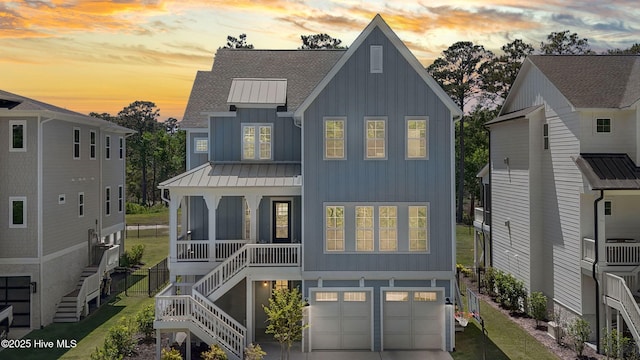 back of house at dusk with board and batten siding, a standing seam roof, roof with shingles, stairway, and an attached garage