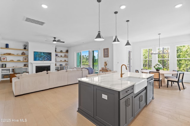 kitchen featuring gray cabinetry, visible vents, a wealth of natural light, and a sink