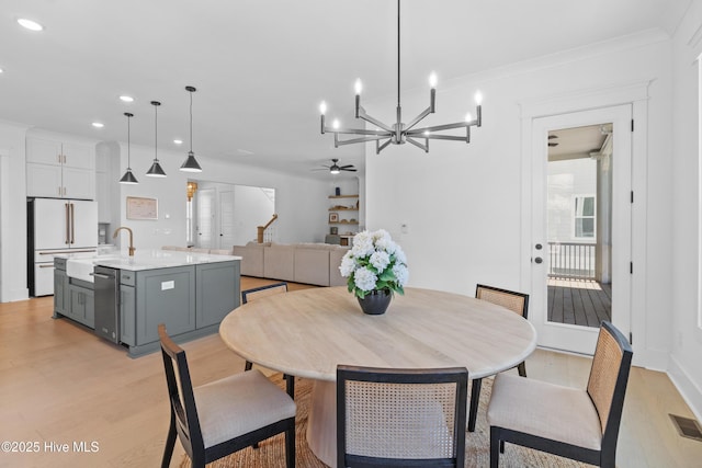 dining space featuring ceiling fan with notable chandelier, recessed lighting, light wood-style flooring, and visible vents