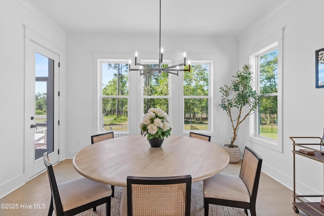 dining room with baseboards, ornamental molding, and light wood finished floors