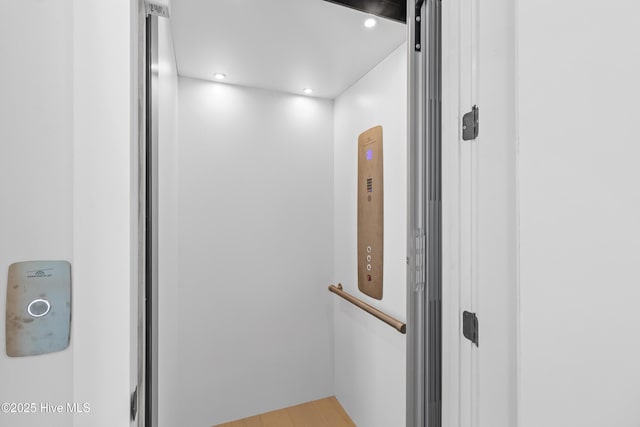details featuring recessed lighting, elevator, and wood finished floors