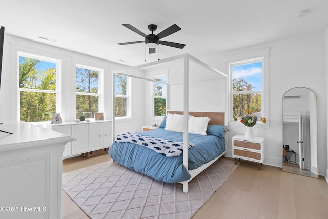 bedroom featuring visible vents, light wood-style floors, ceiling fan, and multiple windows