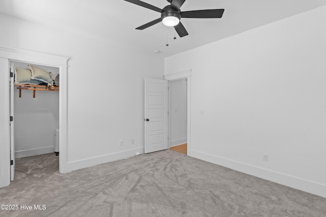 unfurnished bedroom with carpet floors, baseboards, a closet, and a spacious closet