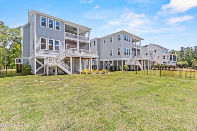 back of property with a yard, a ceiling fan, stairs, and a fenced backyard