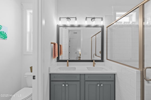 full bathroom with a sink, toilet, and a shower stall