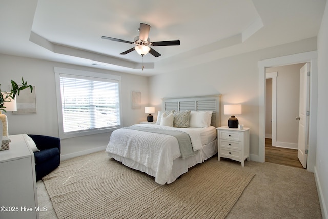 218 Country Club Dr SW, Shallotte, NC 28470 - bedroom featuring visible vents, baseboards, light colored carpet, a tray ceiling, and a ceiling fan