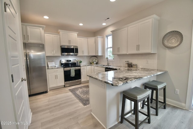 218 Country Club Dr SW, Shallotte, NC 28470 - kitchen featuring light stone counters, a peninsula, tasteful backsplash, and stainless steel appliances