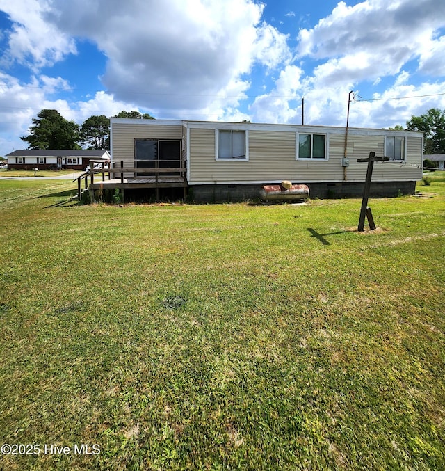 back of property featuring a lawn and a deck