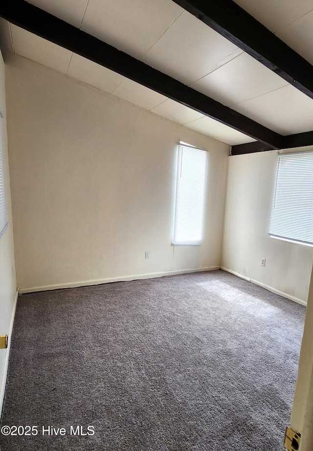 carpeted empty room with baseboards and beamed ceiling