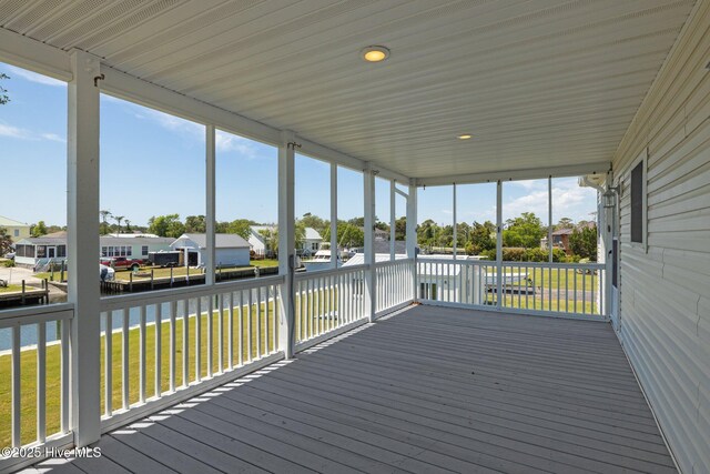 deck featuring a water view, a yard, and a residential view