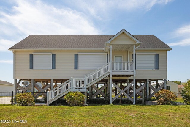 back of property with stairway and a shingled roof