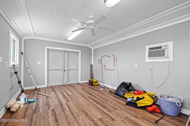 game room featuring wood finished floors, crown molding, baseboards, ceiling fan, and a wall mounted AC