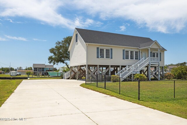 beach home featuring stairway, a carport, driveway, and a porch