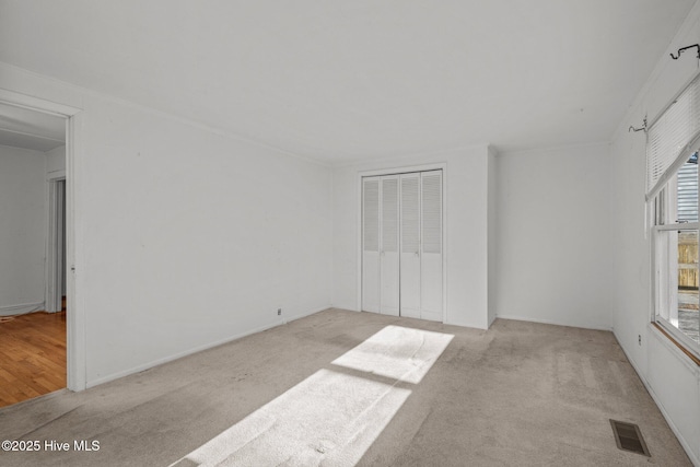 2205 Bay St, Morehead City, NC 28557 - unfurnished bedroom featuring visible vents, light carpet, multiple windows, and a closet