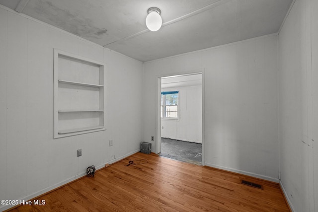 2205 Bay St, Morehead City, NC 28557 - spare room featuring visible vents, built in shelves, and wood finished floors
