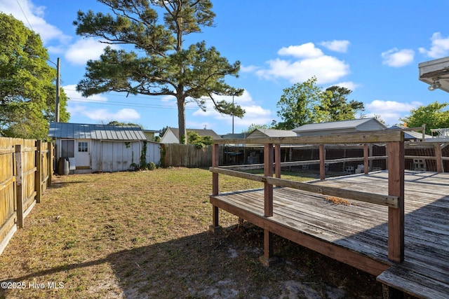 2205 Bay St, Morehead City, NC 28557 - view of yard featuring a storage shed, an outbuilding, a fenced backyard, and a wooden deck