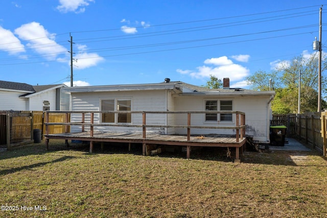 2205 Bay St, Morehead City, NC 28557 - rear view of house featuring a yard, a chimney, a fenced backyard, and a wooden deck