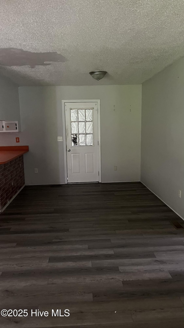 1817 Cobb Rd, Kinston, NC 28501 - unfurnished dining area with dark wood-style flooring and a textured ceiling