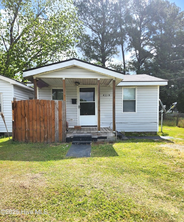 view of front of home featuring a front lawn, fence, and covered porch